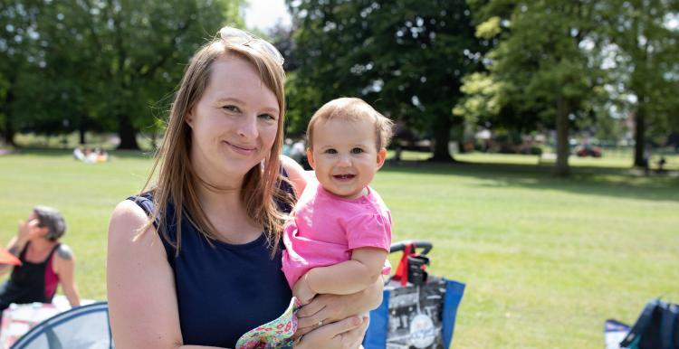 Woman in a sunny park with a young baby