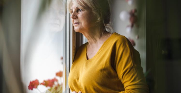 A woman looks pensively out of a window