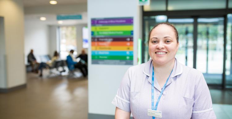 A nurse smiling at the camera in a hospital