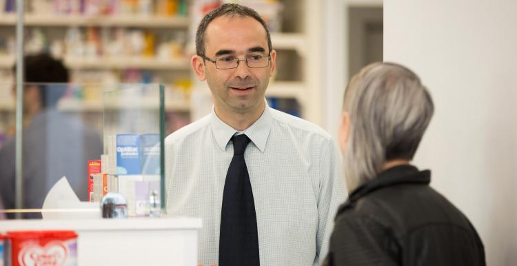 Woman speaking to a male pharmacist