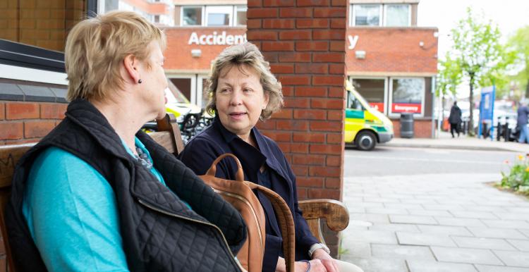 Two_Women_Sitting_Outside_Hosptial_Entrance