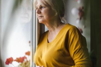 A woman looks pensively out of a window