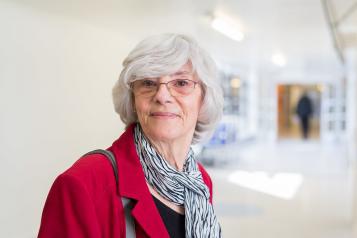 Woman smiling stood in a hospital corridor