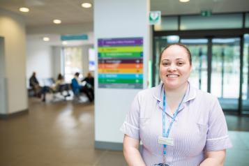 A nurse smiling at the camera in a hospital