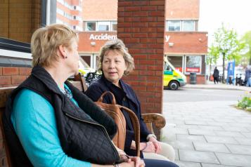 Two_Women_Sitting_Outside_Hosptial_Entrance