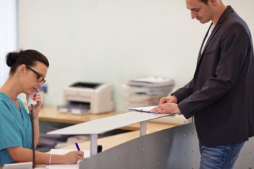 Female receptionist talking on the phone while patient waits