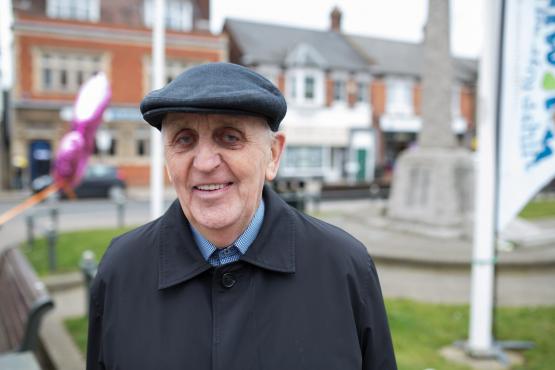 Elderly man wearing a flat hat and coat standing outside Elderly man wearing a flat hat and coat standing outside