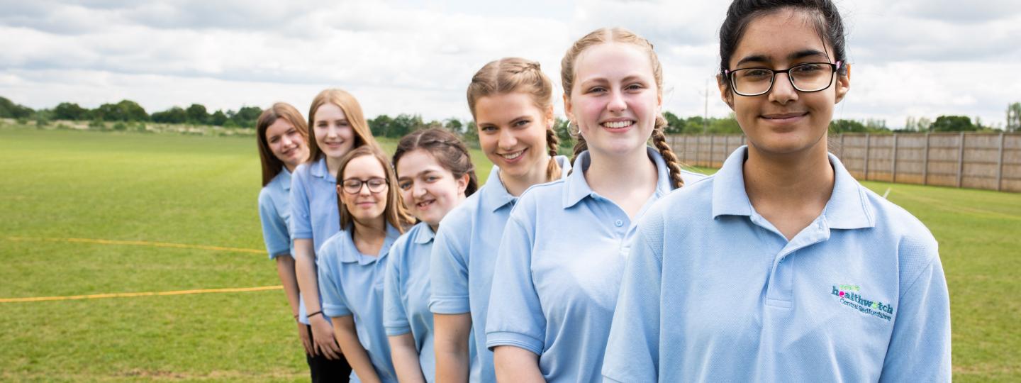 A line of children all wearing blue Healthwatch t shirts