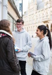 Two teenage Healthwatch volunteers talking to a member of the public about their experience